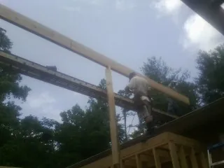 Carpenter setting a ridge beam over a new addition frame — Ice Dam Removal by Roofing Brothers in Pennsauken