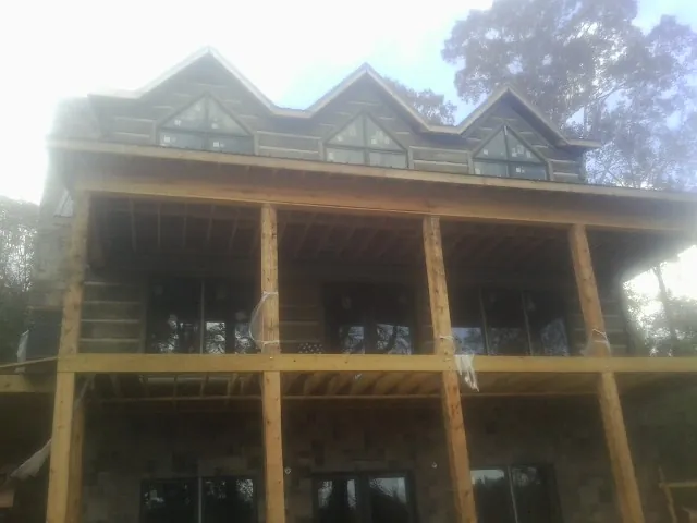 Dormers and porch framing on a large log home under construction — Roof Coating work by our crew in Pennsauken