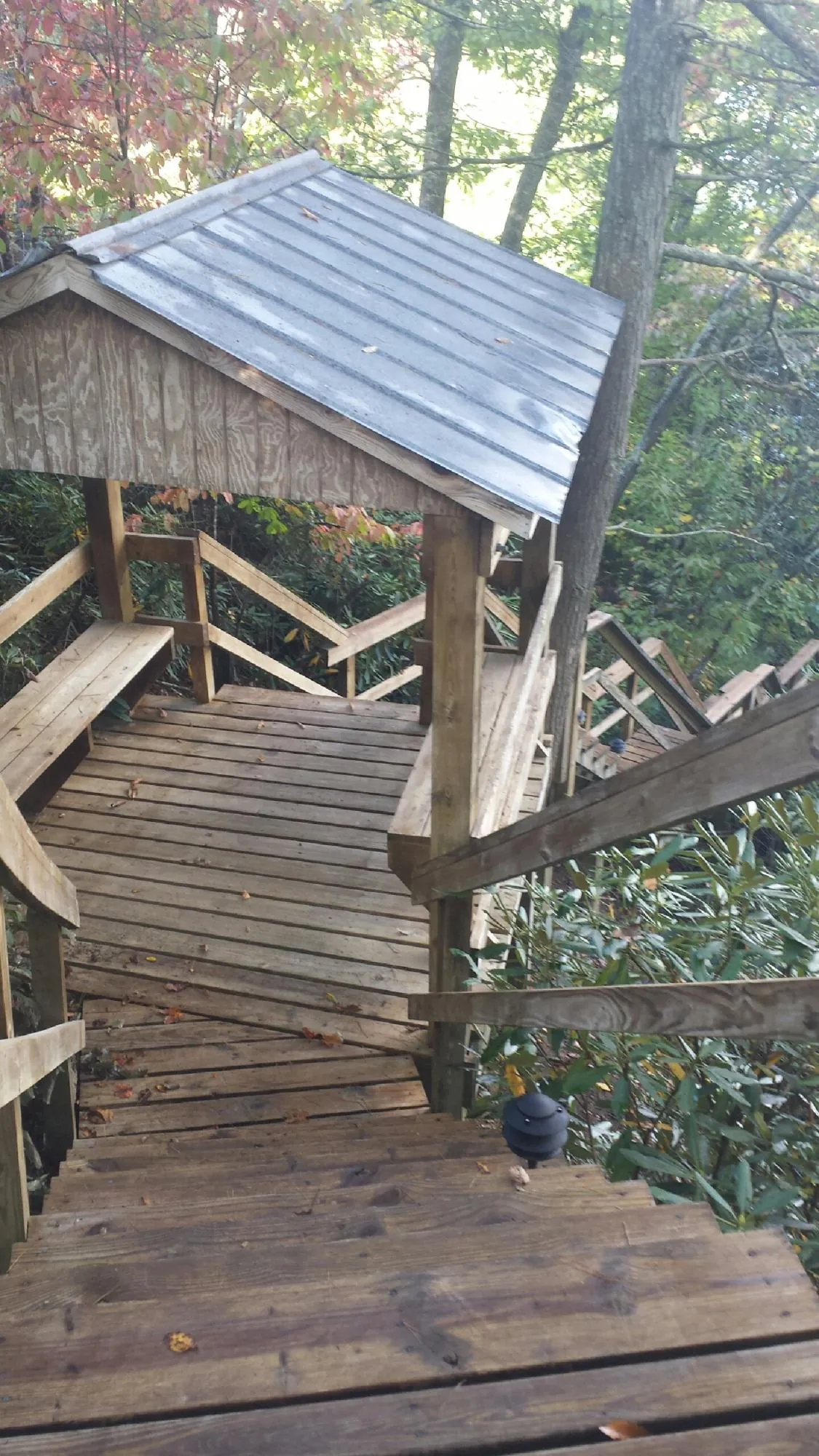 Metal roofed shelter over wooden steps on a wooded walkway — Skylight Repair & Installation work by our crew in Pennsauken